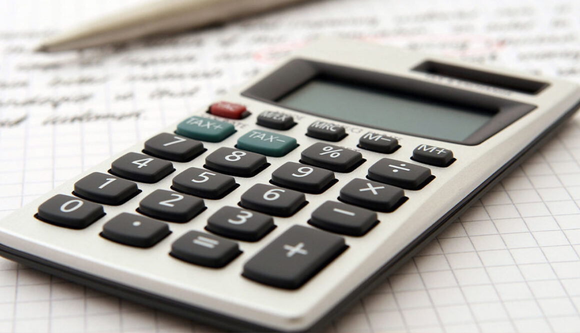 A calculator and pen on graph paper represent Advisors Management Group's fiduciary financial advisory and accounting services in Wisconsin.