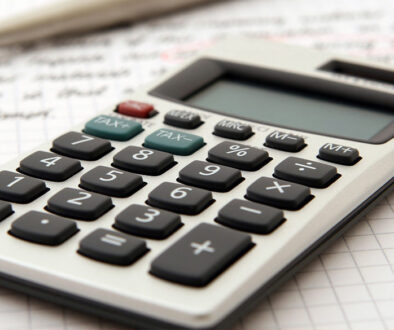 A calculator and pen on graph paper represent Advisors Management Group's fiduciary financial advisory and accounting services in Wisconsin.