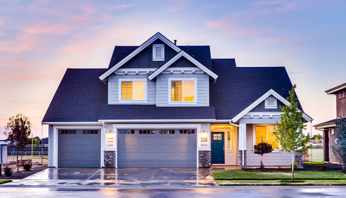A two-story Wisconsin home with a three-car garage and lit windows at sunset, reflecting financial security and planning.