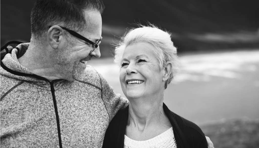 An older couple smiles outdoors in Wisconsin, happy with their investment advisory experience with fiduciary financial advisors.