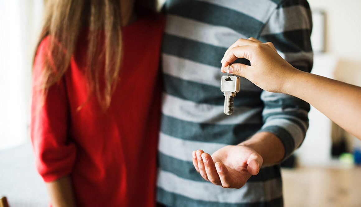 A hand gives a key to a couple, representing the trust clients have in Advisors Management Group’s fiduciary advisors in Wisconsin.