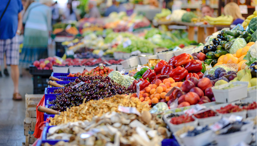 Colorful fresh produce at a lively Wisconsin outdoor market, reflecting local community vitality served by fiduciary financial advisors.