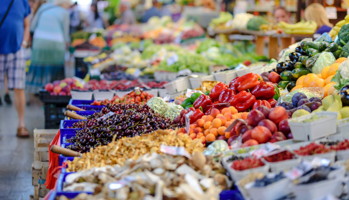 Colorful fresh produce at a lively Wisconsin outdoor market, reflecting local community vitality served by fiduciary financial advisors.