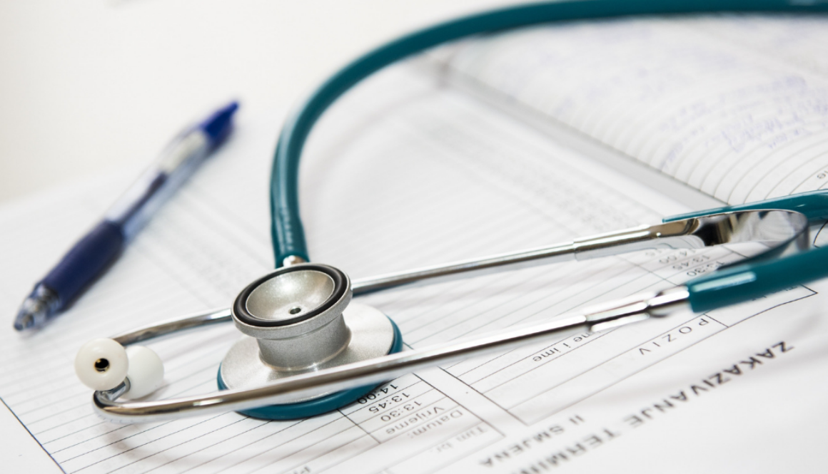 A stethoscope with medical paperwork and a blue pen highlights healthcare accounting services from fiduciary advisors in Wisconsin.
