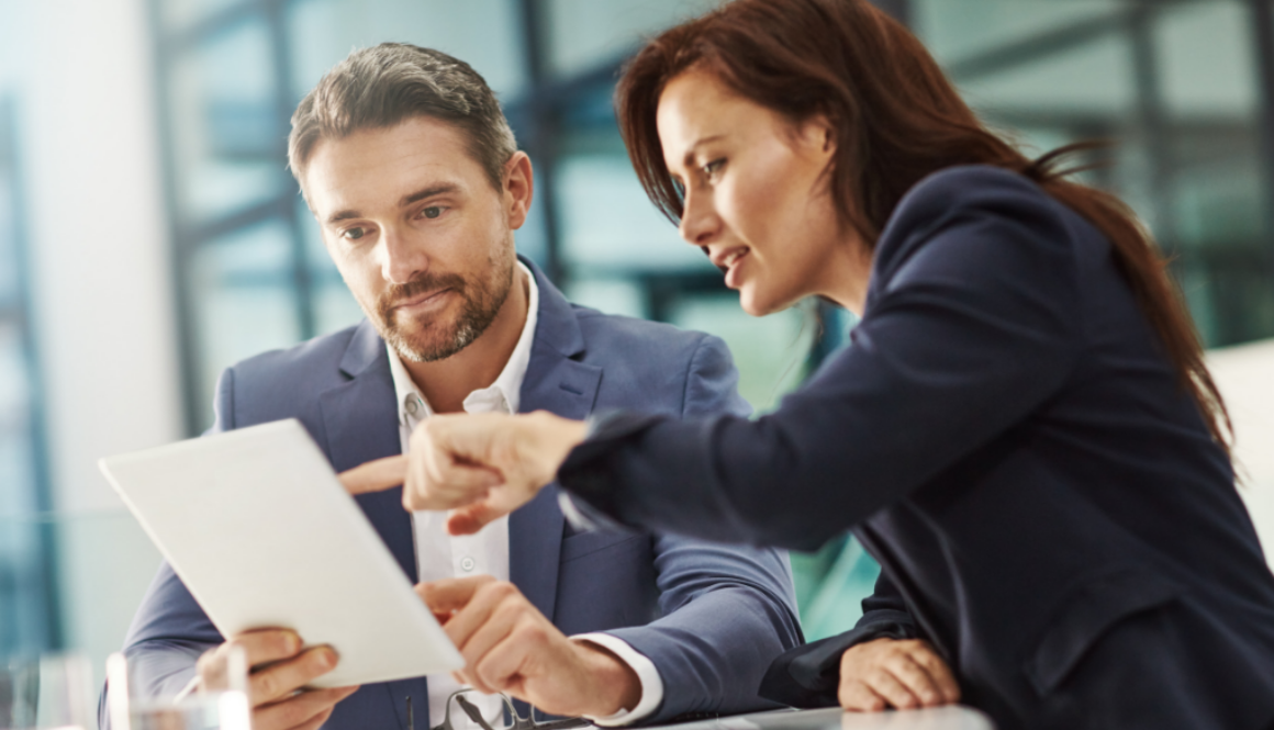 Two fiduciary financial advisors in a modern Wisconsin office review financial planning documents for Advisors Management Group.