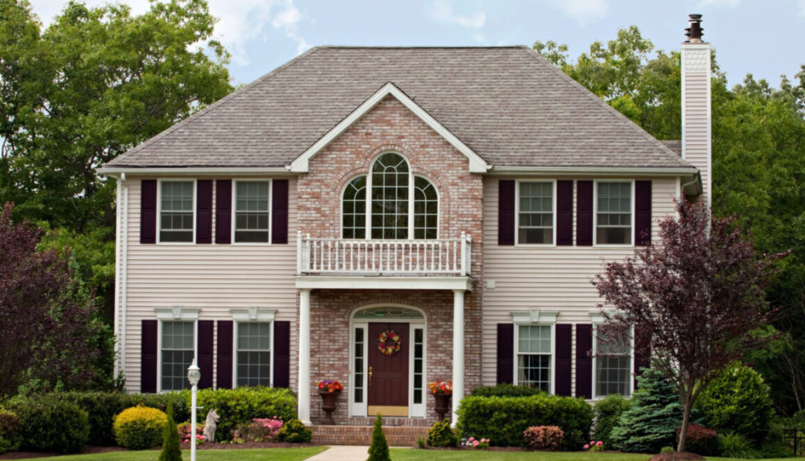 Two-story suburban home with brick and siding, front porch, and landscaped yard—ideal for Wisconsin fiduciary financial planning.