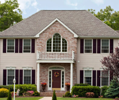 Two-story suburban home with brick and siding, front porch, and landscaped yard—ideal for Wisconsin fiduciary financial planning.