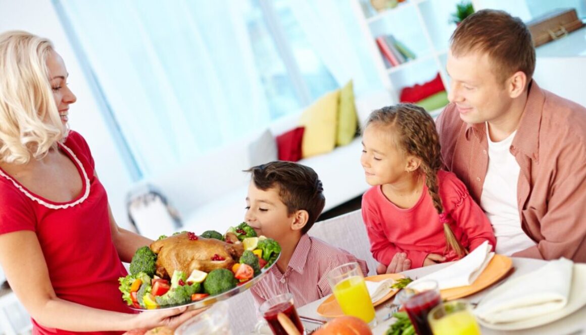 A happy family enjoys a home-cooked meal together in their cozy Wisconsin dining room, symbolizing financial well-being and planning.