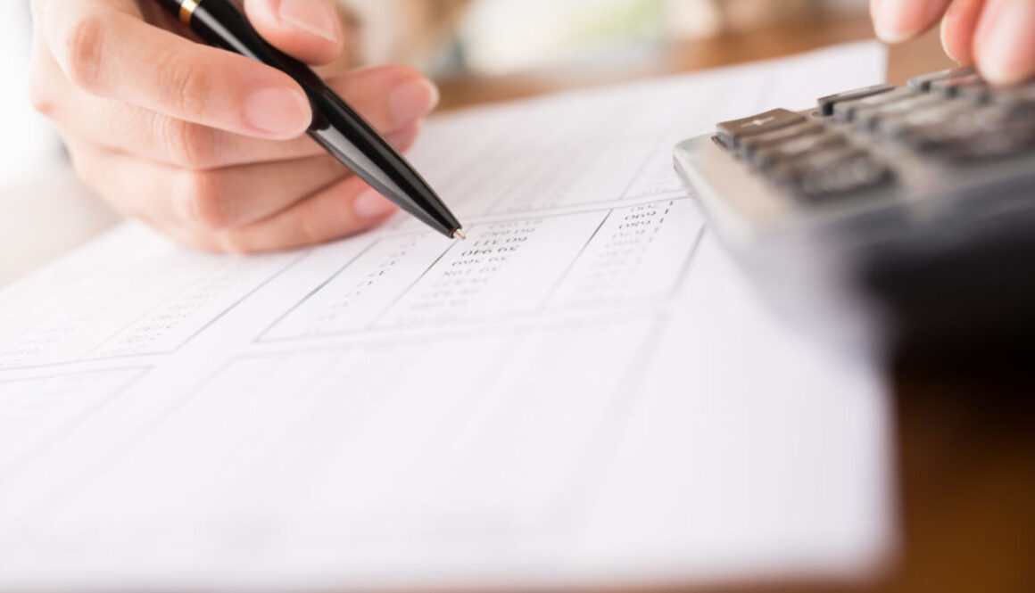 A fiduciary financial advisor in Wisconsin reviews investment advisory documents on a desk at Advisors Management Group.