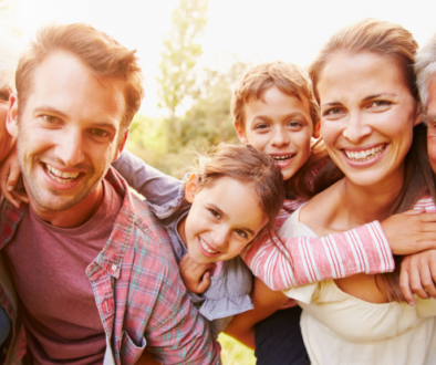 Three generations, including the Sandwich Generation, smile together outdoors—reflecting family financial planning in Wisconsin.