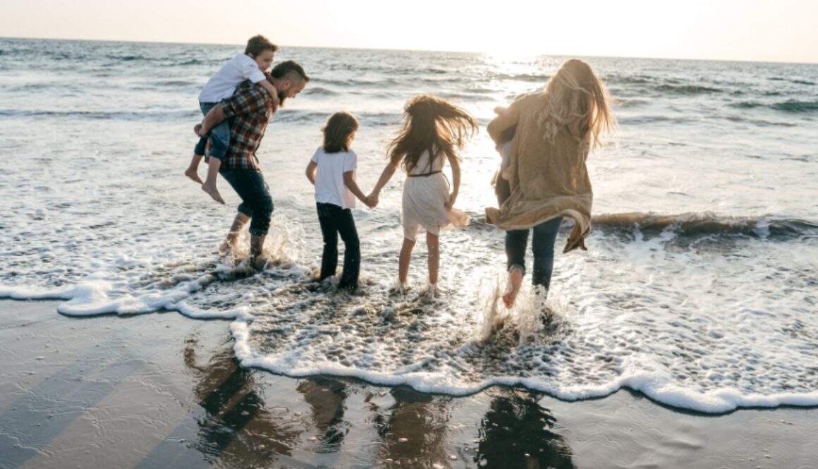 A family standing on the beach in the ocean.
