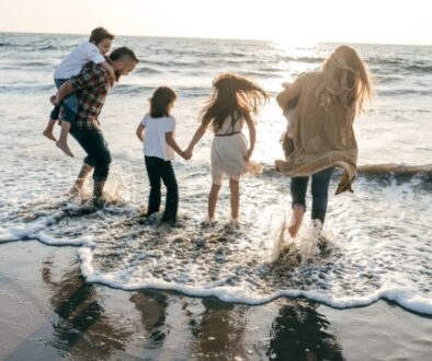 A family standing on the beach in the ocean.