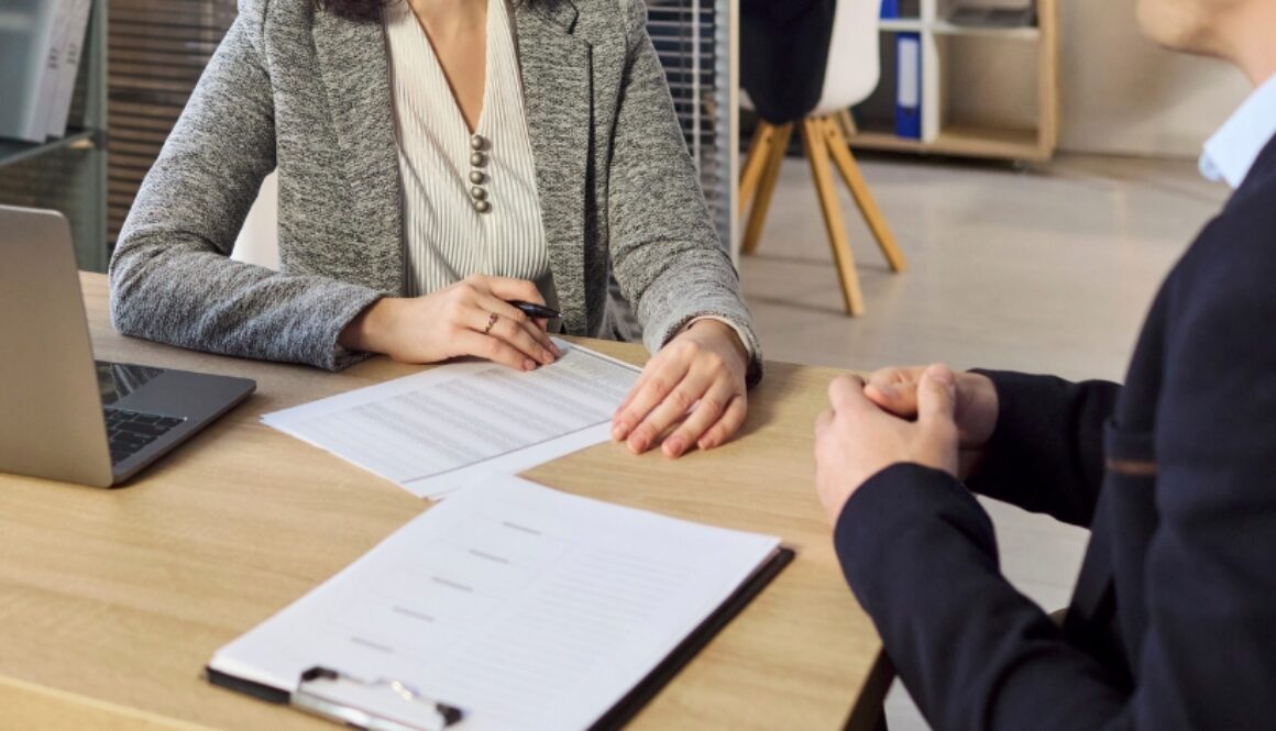 A financial advisor meeting with a client and going over paperwork.