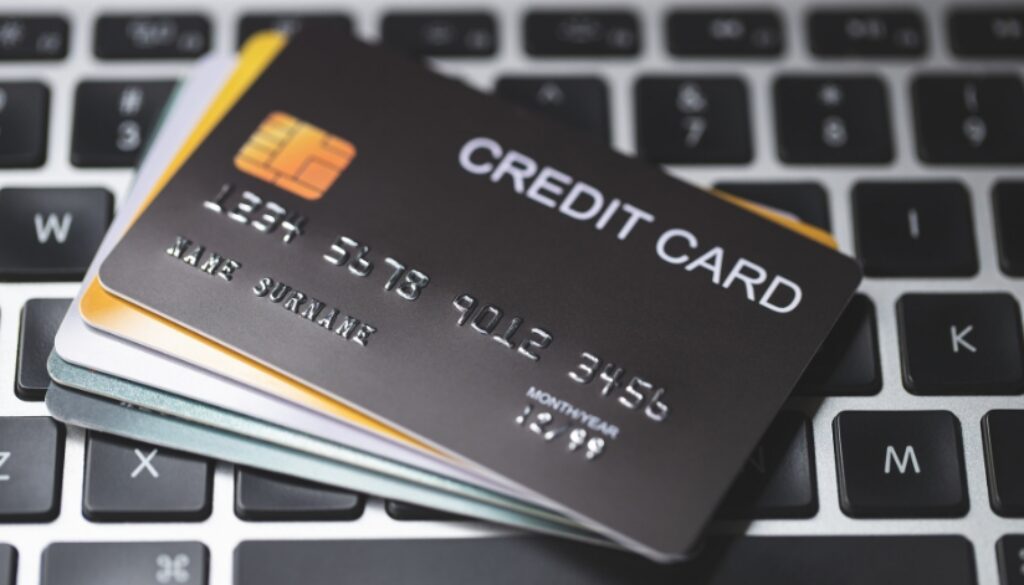 Stacks of credit cards on a laptop keyboard.