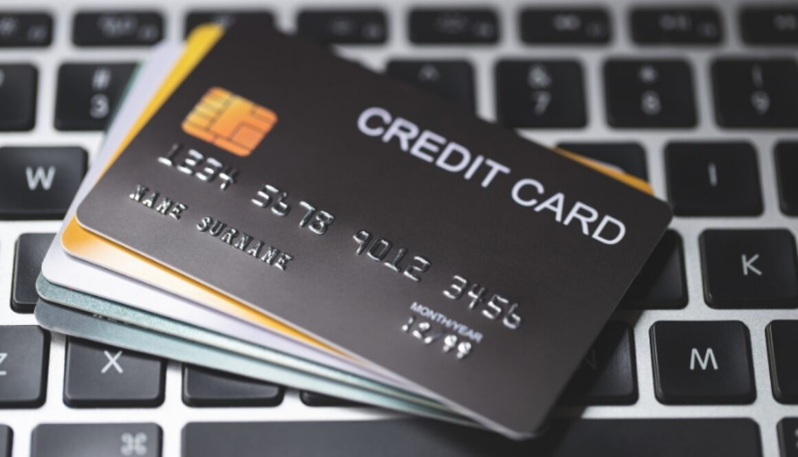 Stacks of credit cards on a laptop keyboard.