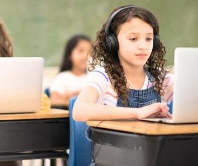 Children in a school classroom working on laptops.